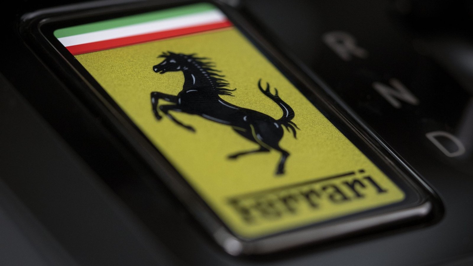 Chave de vidro da Ferrari Luce com o escudo amarelo, encaixada no console
